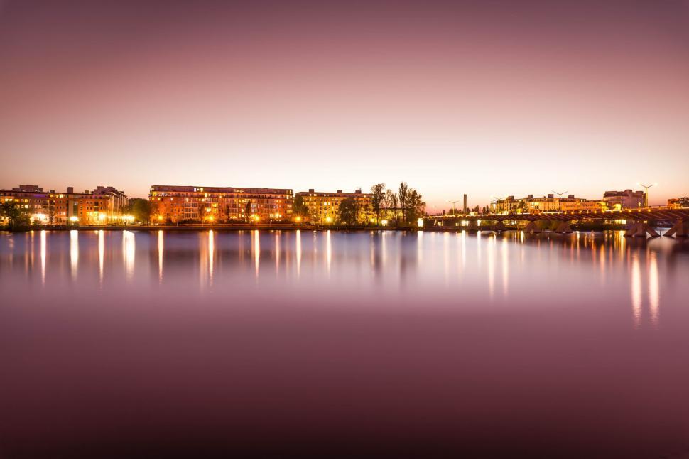 Free Image of Lake and Building lights at sunset 