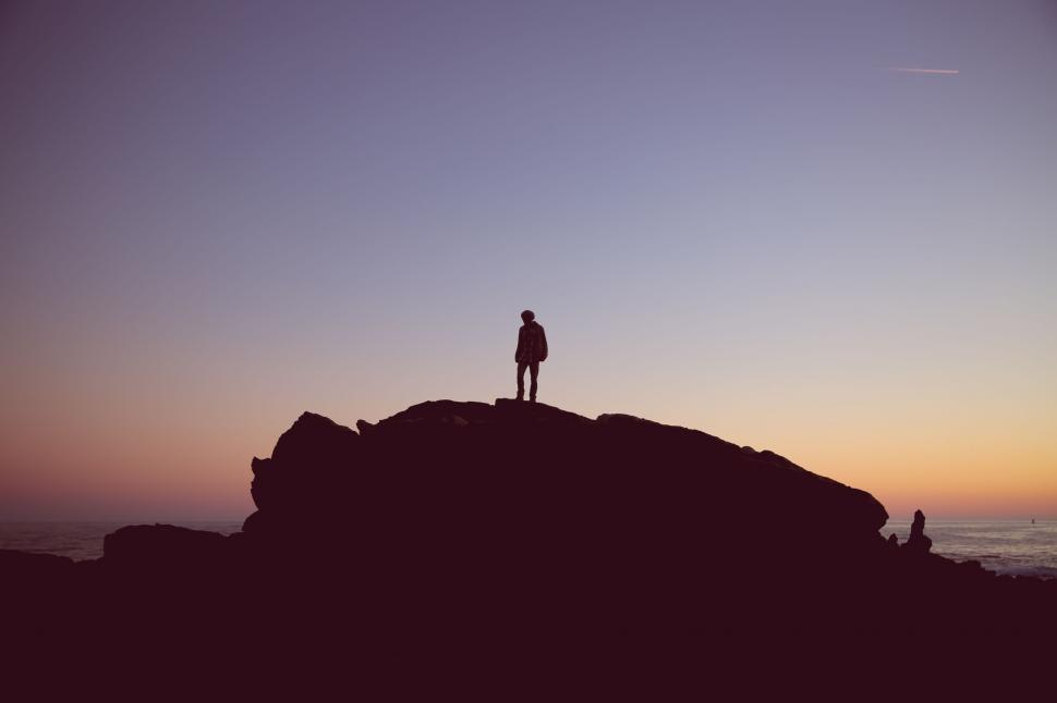 Free Image of Rear view of Man on rock during sunset  