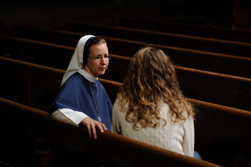 Free Image of Nun and Woman sitting on bench in church 