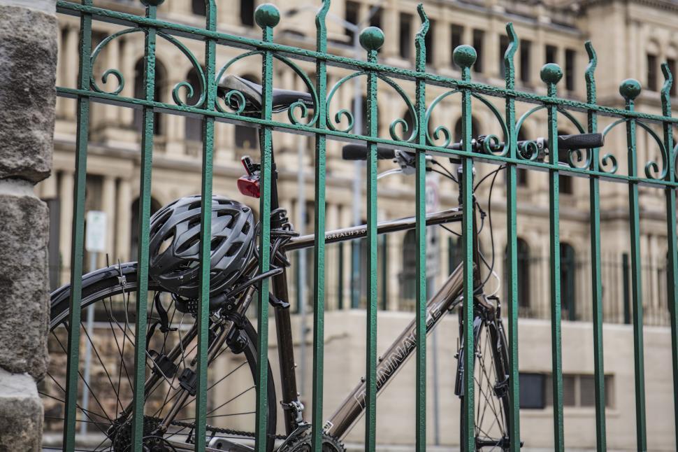 Free Image of Bicycle tied to iron gate fence 