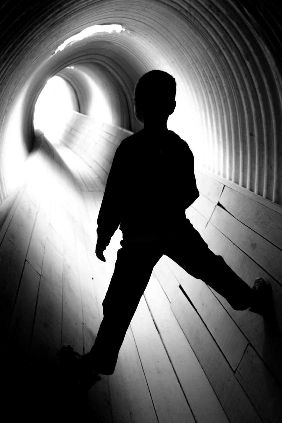 Free Image of Black and White View of Little Boy in Tunnel  