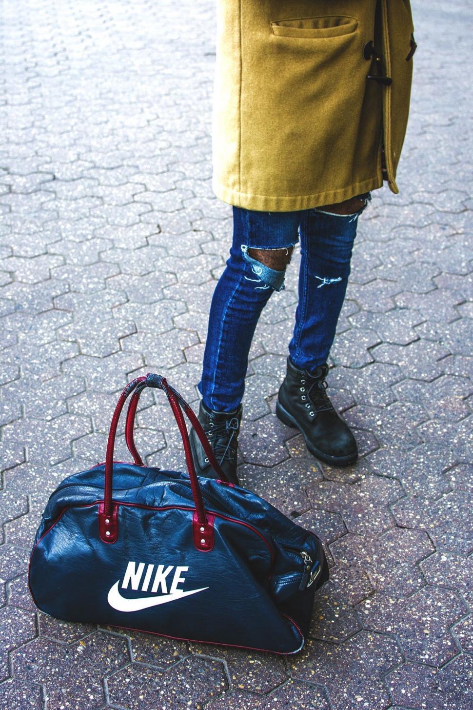 Free Image of Man In Ripped Jeans with Nike Bag  