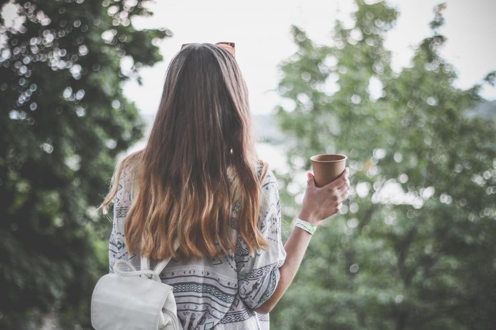Free Image of Back view of woman with brown paper coffee cup  