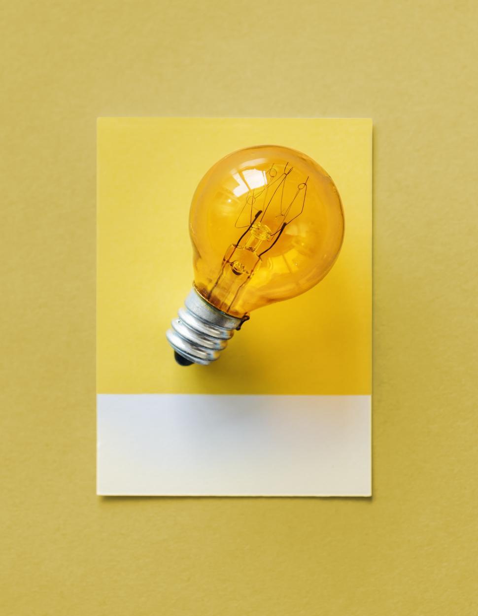 Free Image of Flat lay a small lightbulb on yellow paper background 