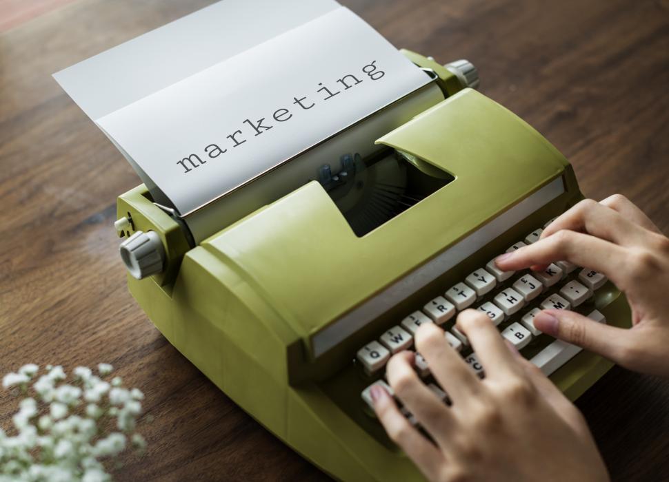 Free Image of Close up of hands typing marketing on a green vintage typewriter 