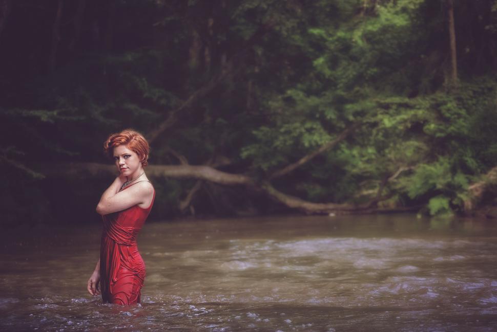 Free Image of Young Woman in Red Dress With Lake and Trees 