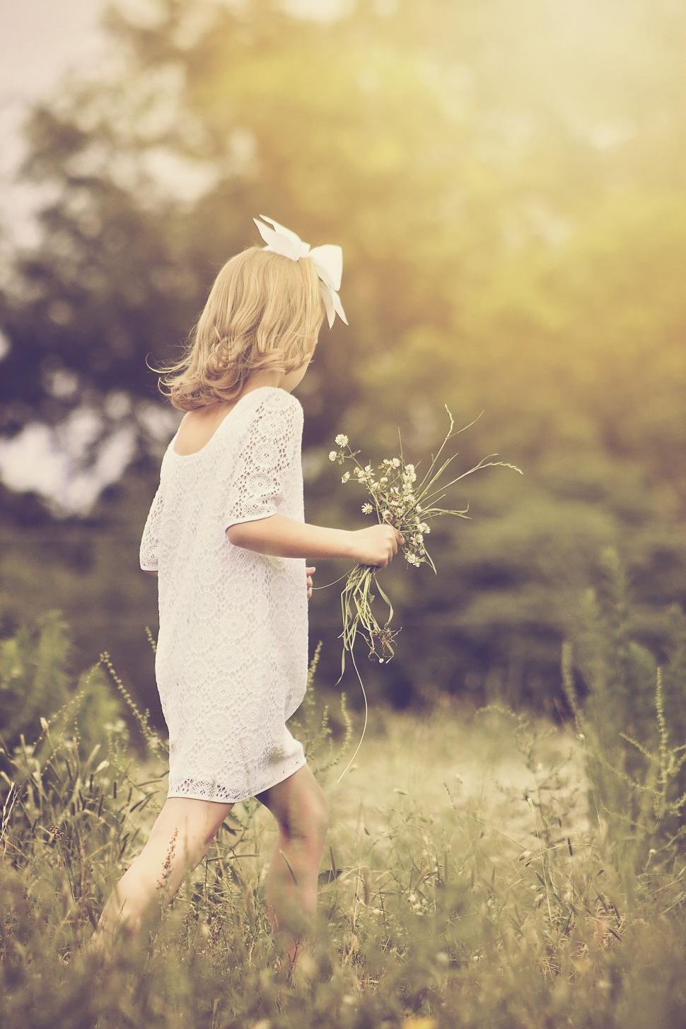 Free Image of Young Girl Walking With Flowers  