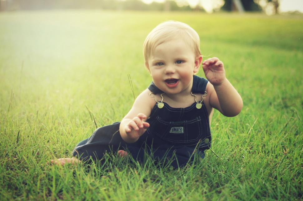 Free Image of Little Boy Playing in Grass Field - looking at camera 