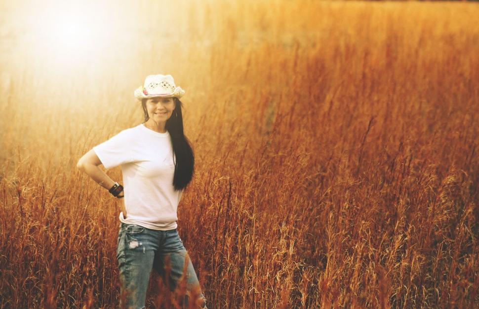 Free Image of Woman In Hat Standing in Hay-field - looking at camera  