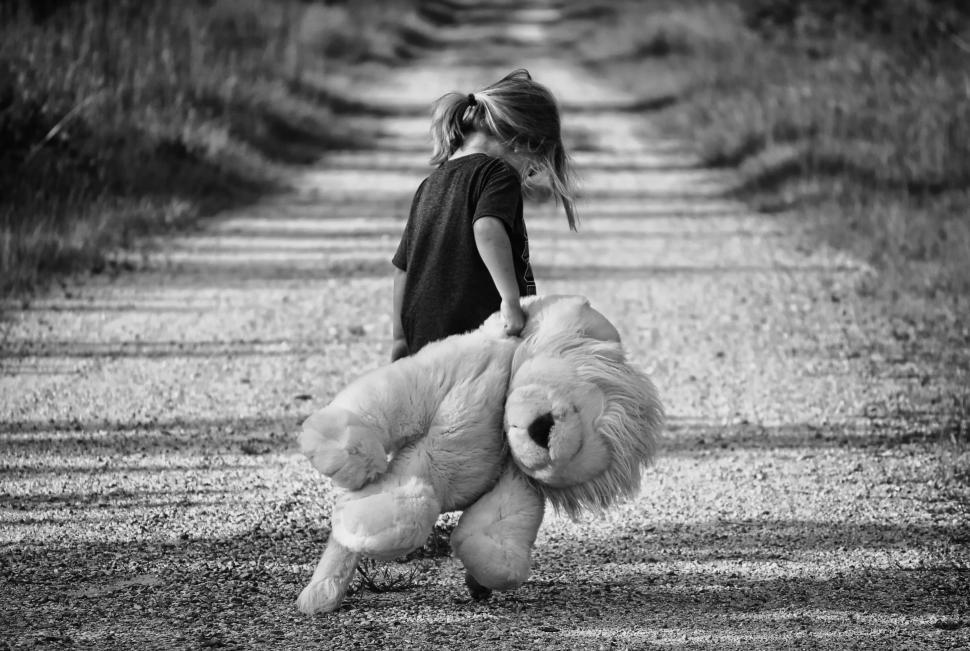 Free Image of Black and White View of Little Girl Walking With Teddy Bear 