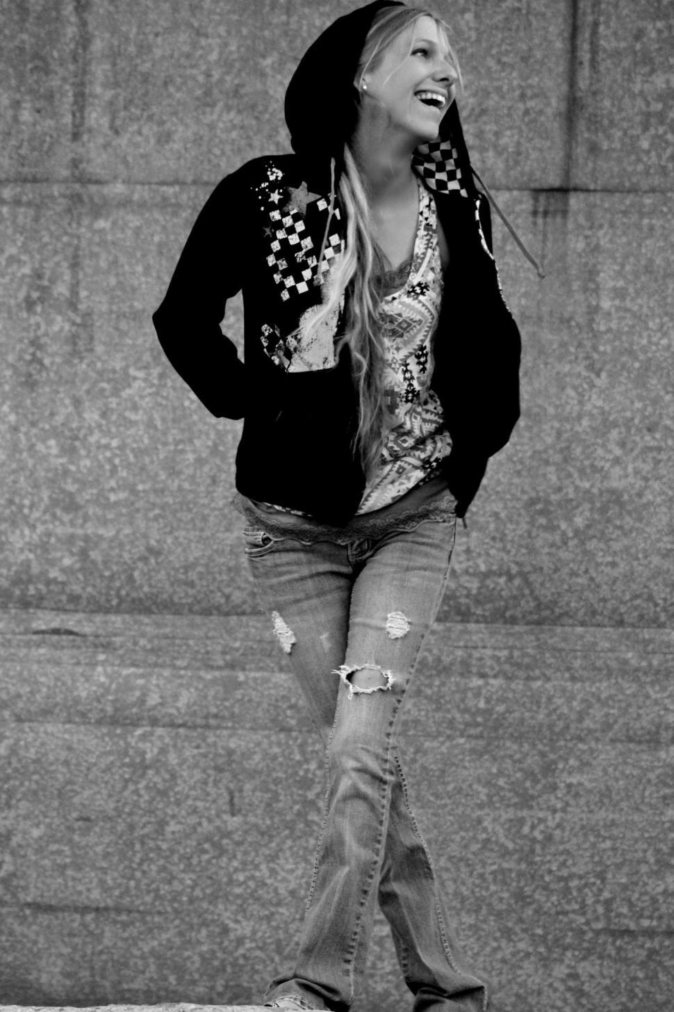 Free Image of Stylish Woman in black hooded jacket and ripped jeans - B&W 