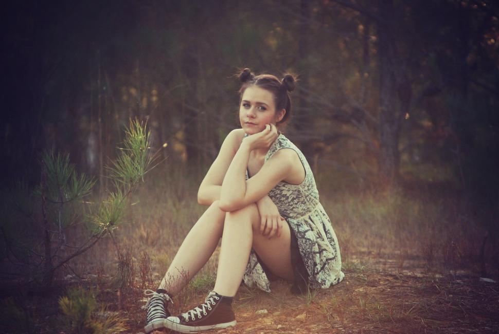 Free Image of Teenage Girl Sitting in the forest - looking at camera 