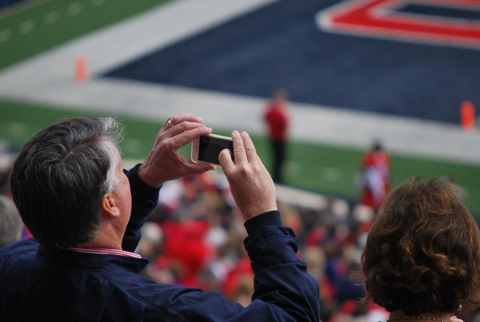 Free Image of Spectator taking pictures with iPhone during American Football Match 