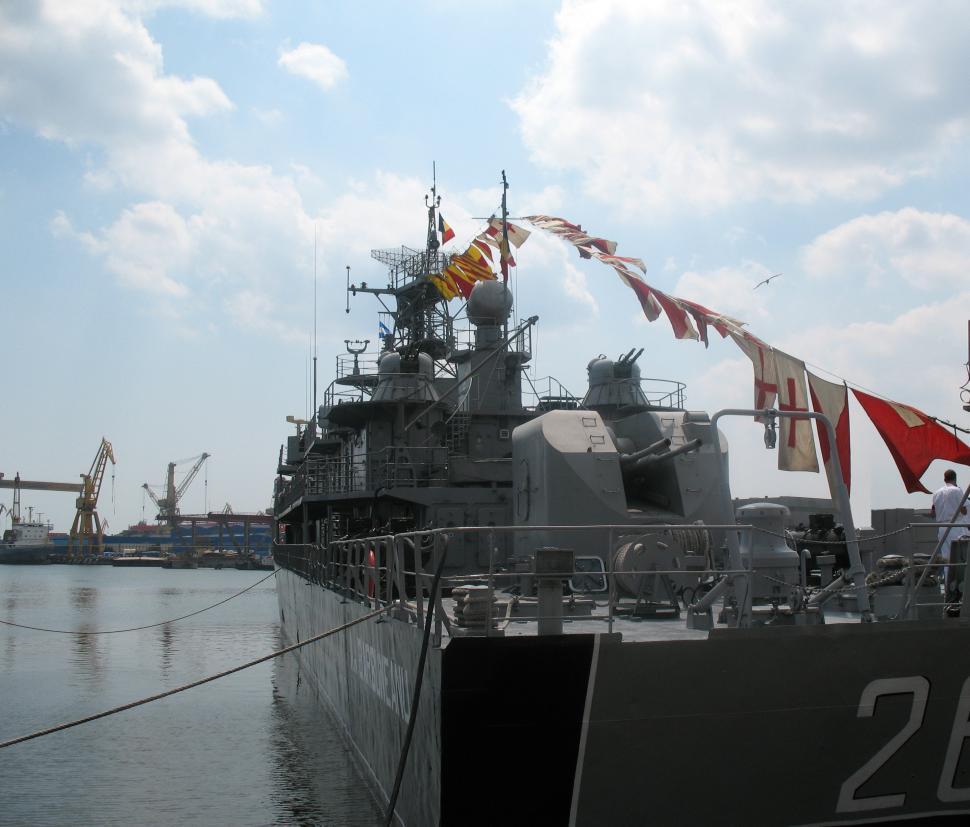 Free Image of A war ship at the dock open ocean in the background 