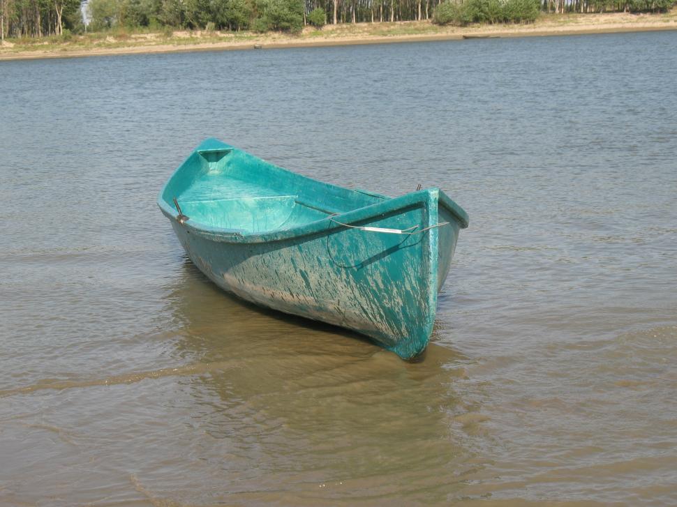 Free Image of Small empty blue boat in the middle of a river 