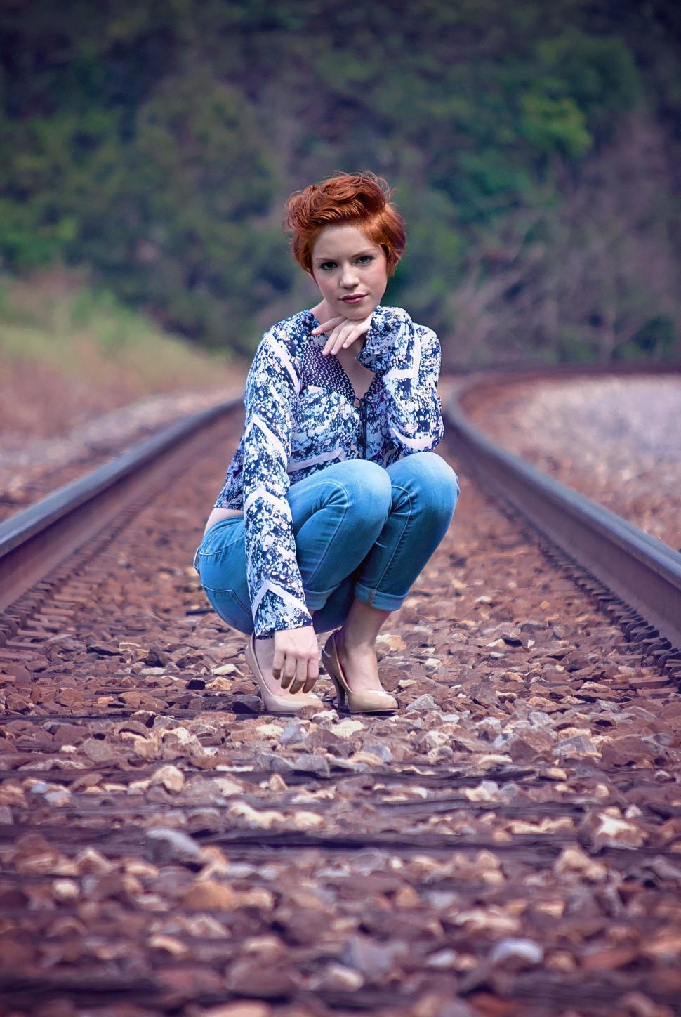 Free Image of Redhead Woman Squatting on Rail-track  