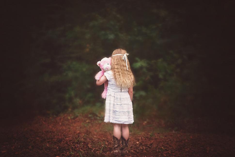 Free Image of Little Girl Standing With Teddy Bear  