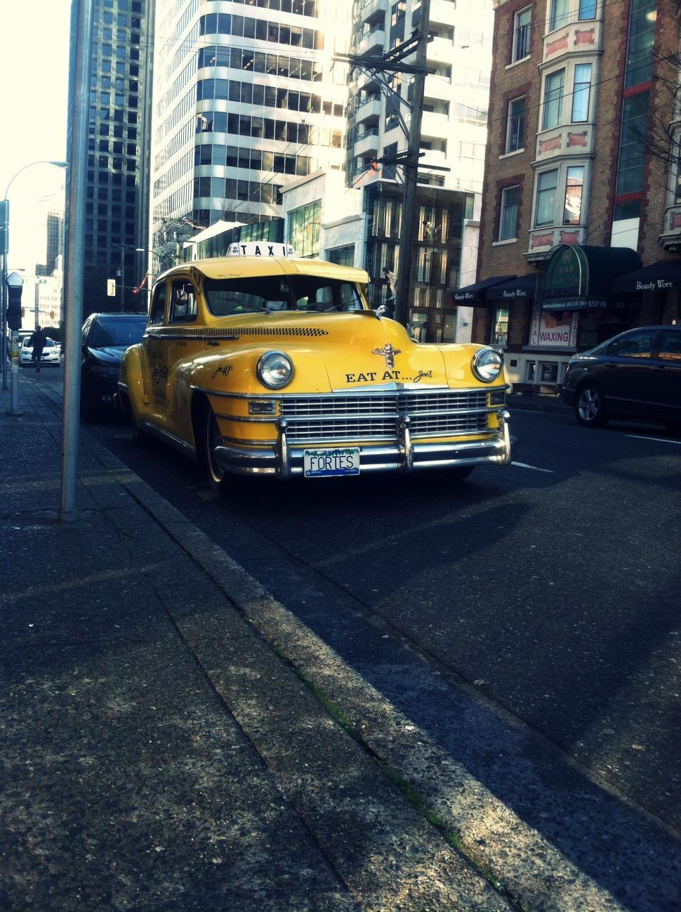 Free Image of Vintage Yellow Taxi Cab and City Buildings  