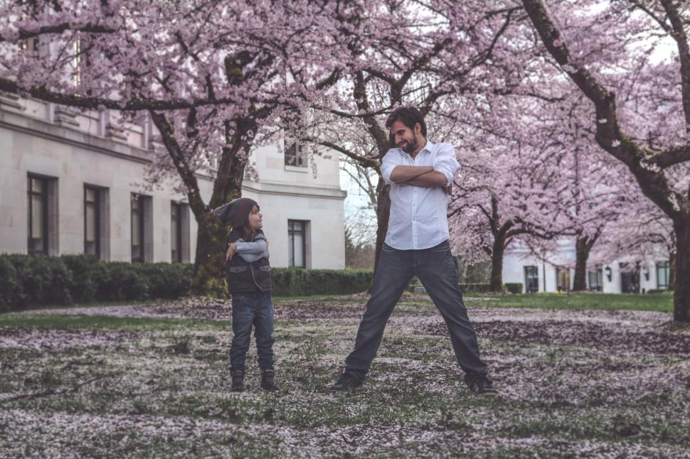 Free Image of Father and Son With Cherry Blossom Trees and Flowers  