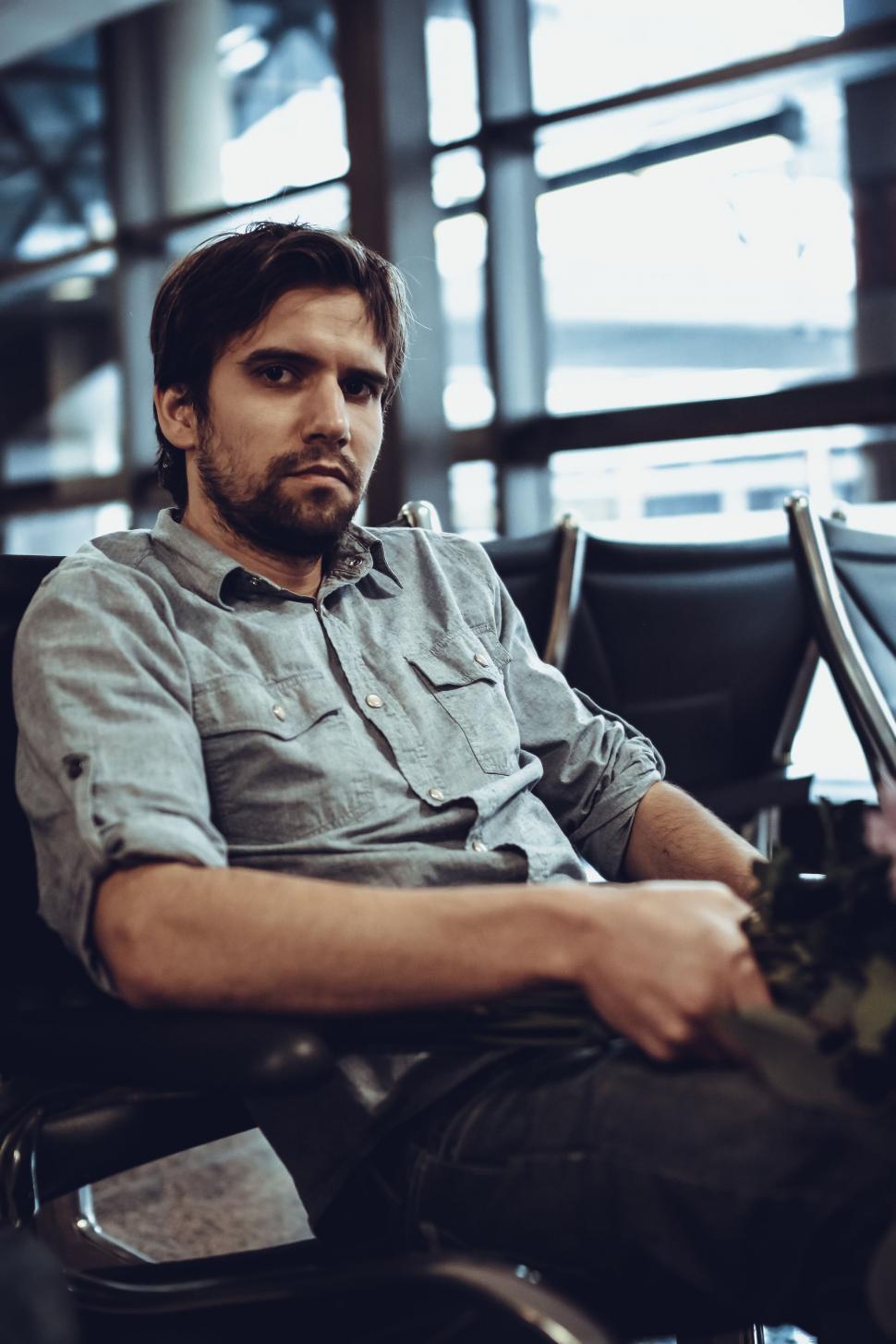Download Free Stock Photo of Young Man waiting at the airport - looking at camera  