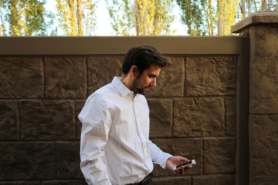 Free Image of Young Businessman with Mobile Phone - Looking Down 