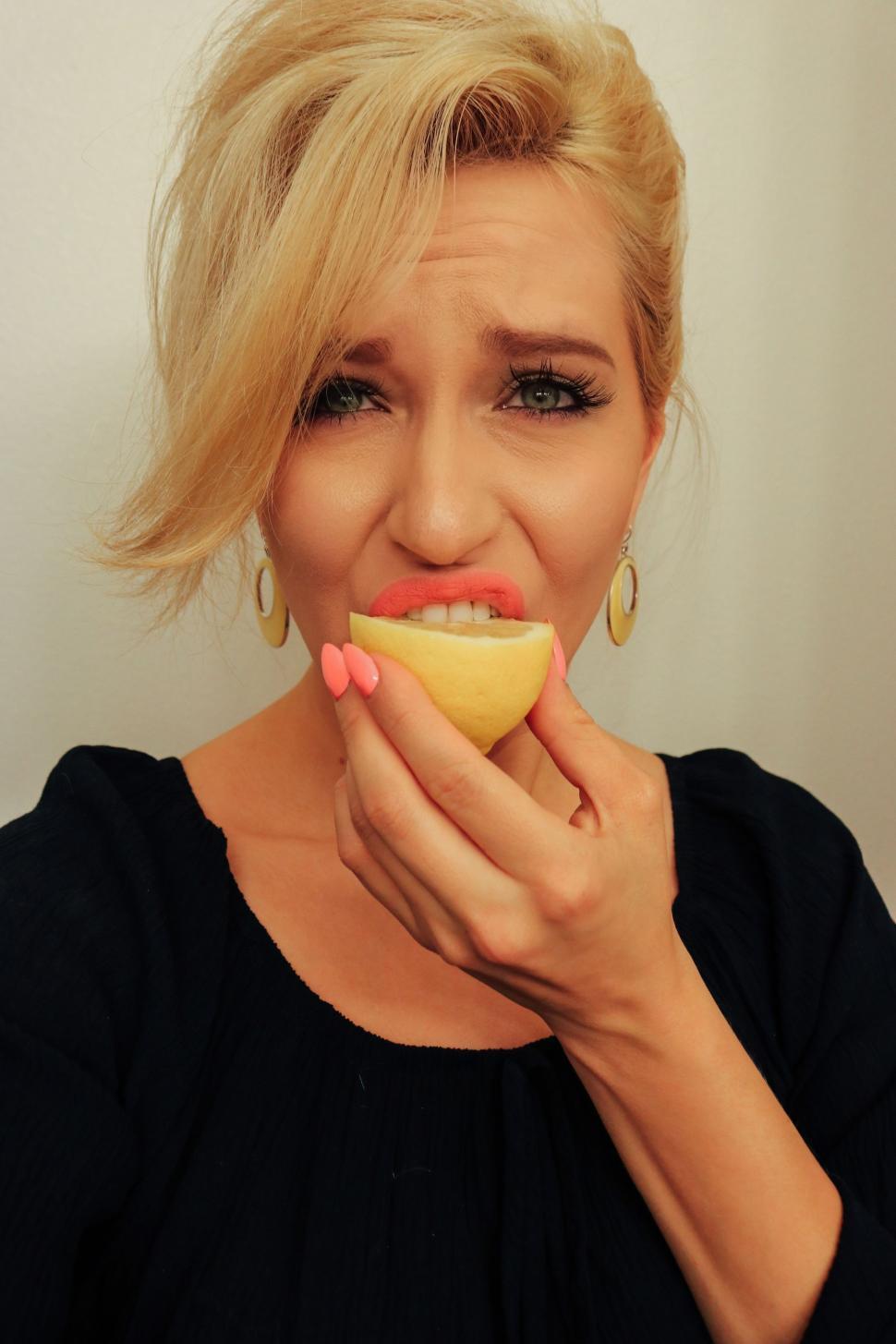 Free Image of Woman tasting slice of lemon - looking at camera  