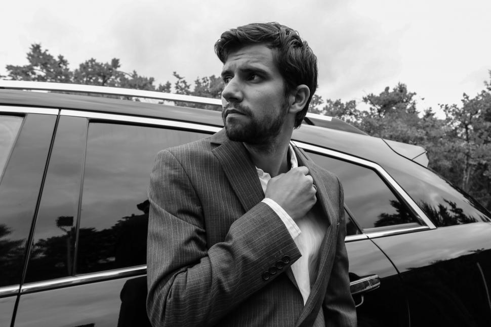 Free Image of Businessman standing with car - looking away 