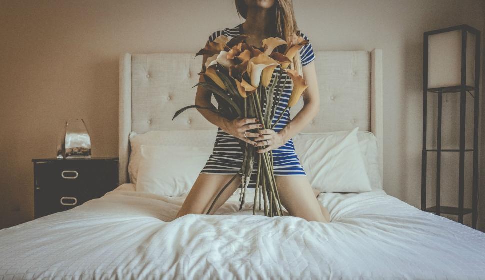 Free Image of Woman on Bed with Flowers - Face not seen  