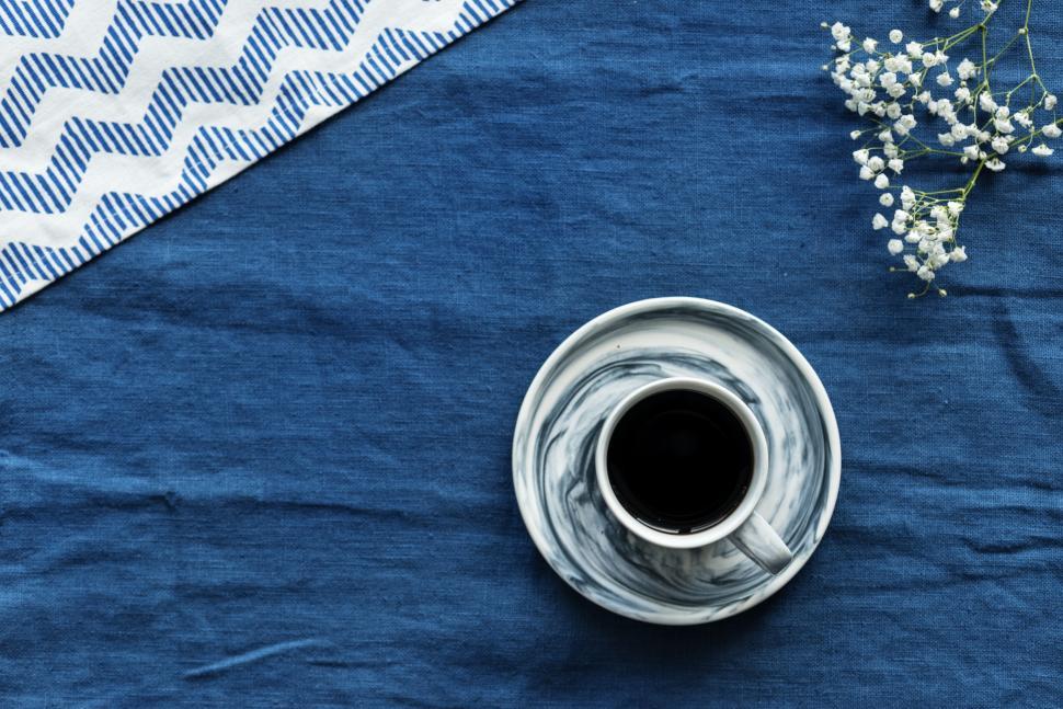 Free Image of Flat lay of a cup of coffee on blue background 