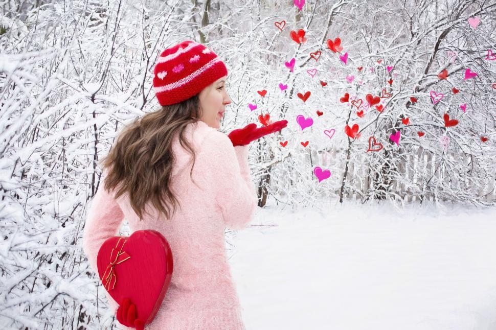 Free Image of Woman Blowing Heart Kisses in Snow 