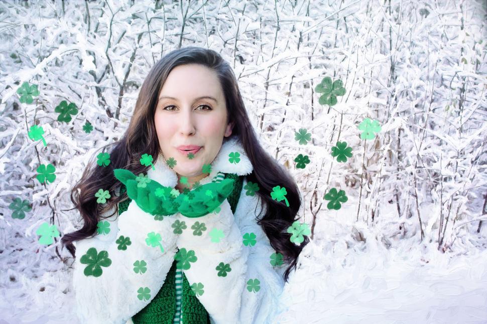 Free Image of Woman blowing shamrocks in snow - Looking at camera 