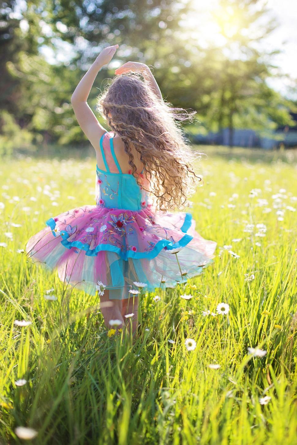 Free Image of Back view of little girl dancing in flower field 