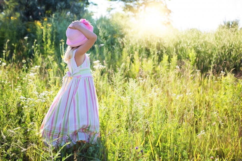 Free Image of Little Girl in pink hat in the meadow  