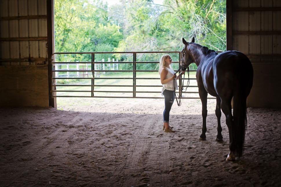 Free Image of Blonde Woman with horse in the barn  