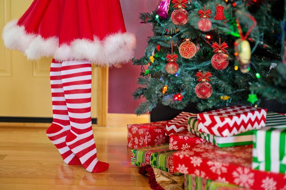 Free Image of Little Girl in red white striped socks with Xmas presents  