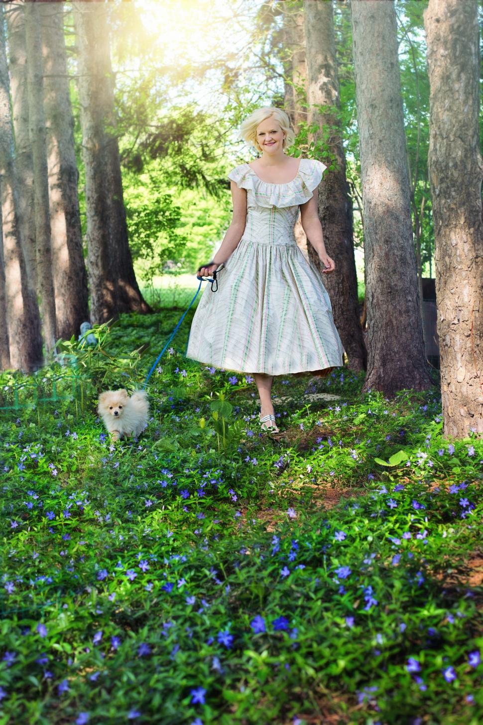 Free Image of Smiling Woman With Pomeranian dog in the garden - Looking at camera  
