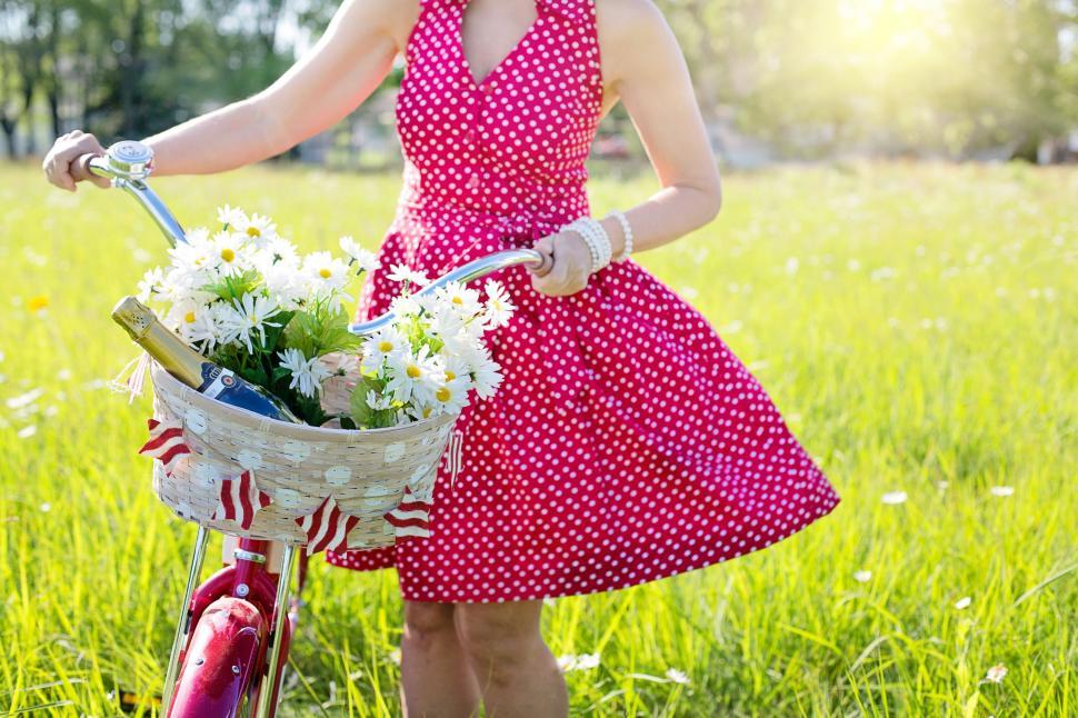 Free Image of Red Dress Woman With Bicycle And Flowers 