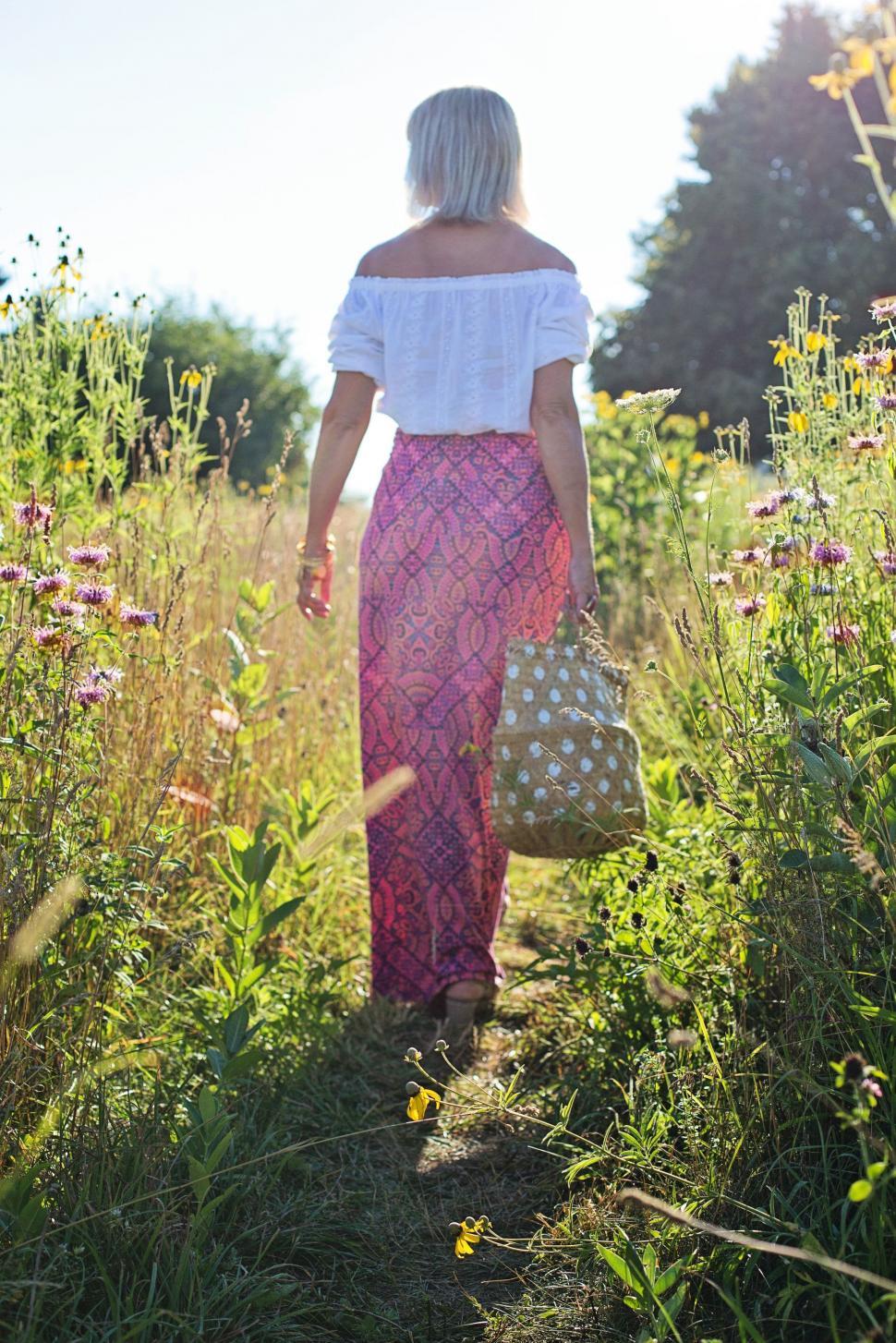 Free Image of Back View of Blonde Woman Walking in the Meadow  