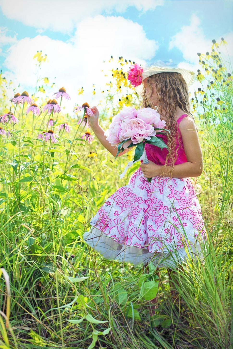 Free Image of Little Girl in Hat With Pink Flowers Bouquet in the meadow  