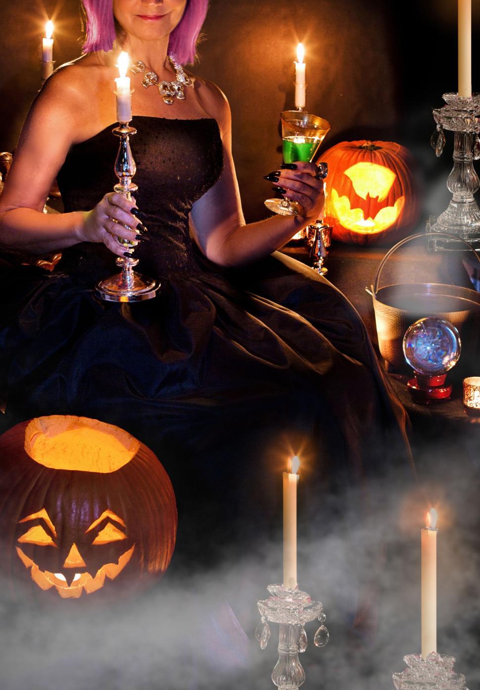 Free Image of Woman With Candles And Halloween Pumpkins 