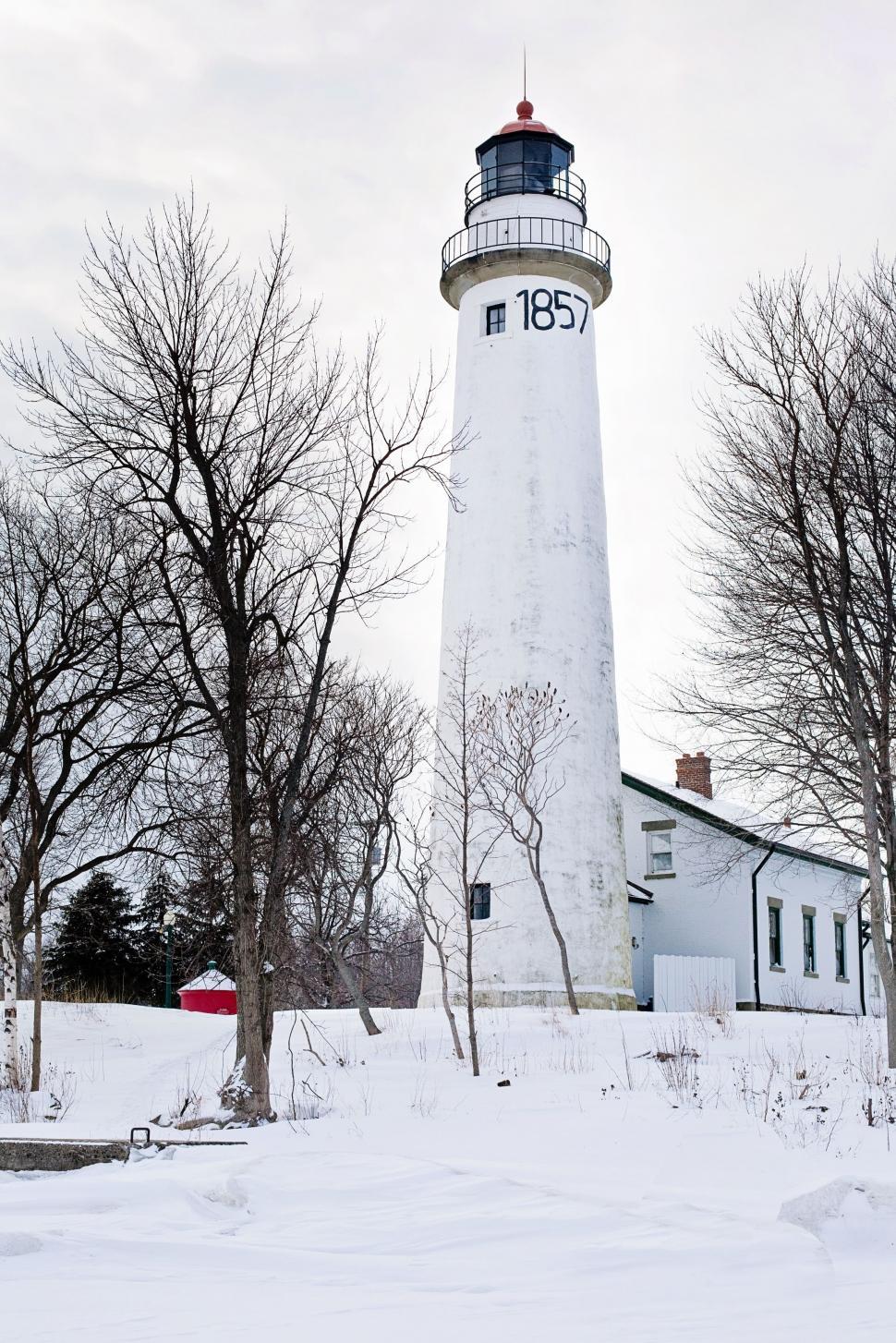 Free Image of Lighthouse and leafless trees in snow  