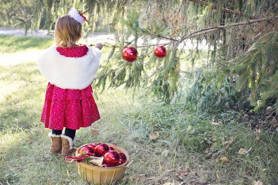 Free Image of Little Girl and Tree with Christmas Ornaments 