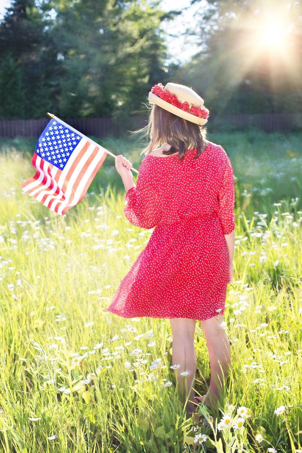 Free Image of Back View of Woman in Hat With American Flag In Flower Field 