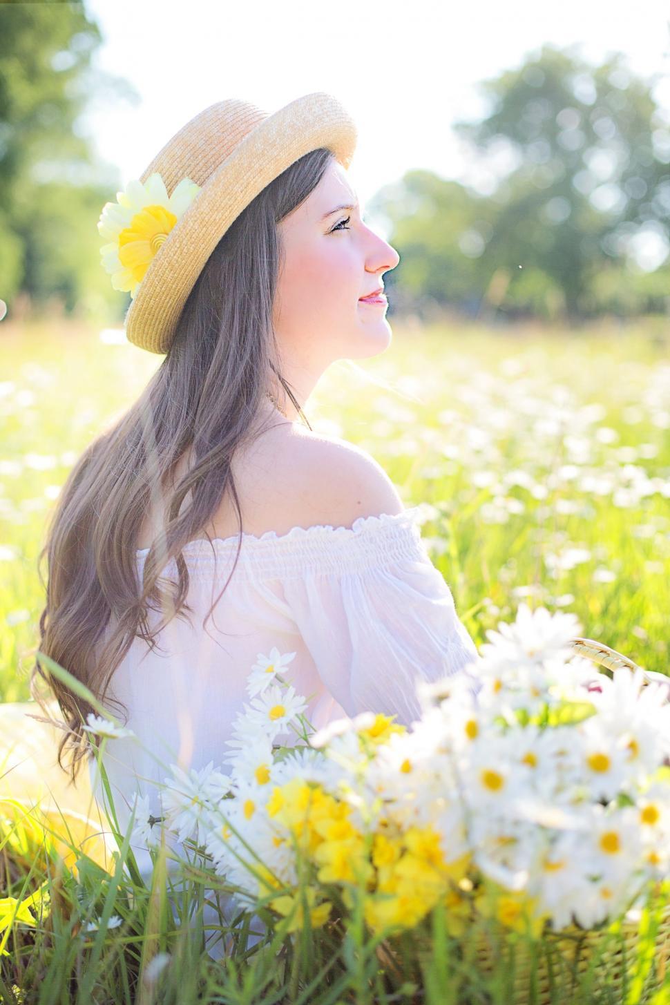Free Image of Woman With Hat in White Flower Field - Looking away  