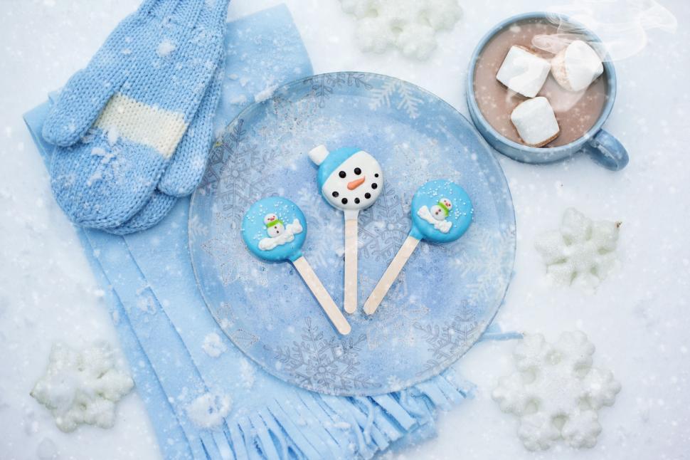 Free Image of Chocolate Cup With Lollipop Candies on Blue Plate in Snow 