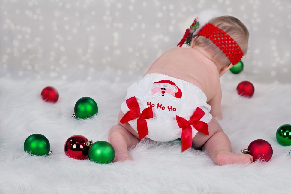 Free Image of Back view of newborn baby with red and green Christmas balls 