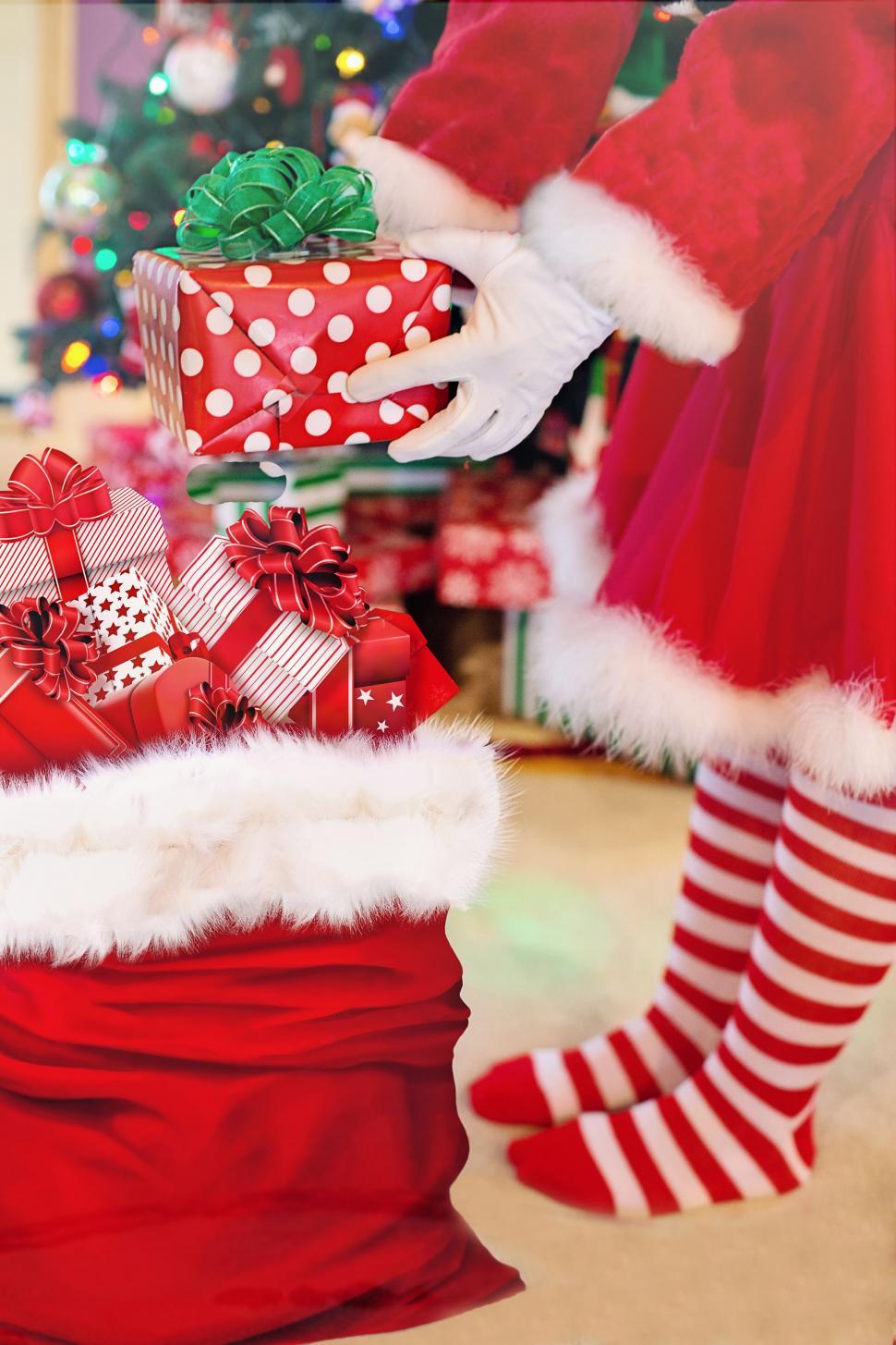 Free Image of Santa Woman in Red White Striped Socks With Gifts 