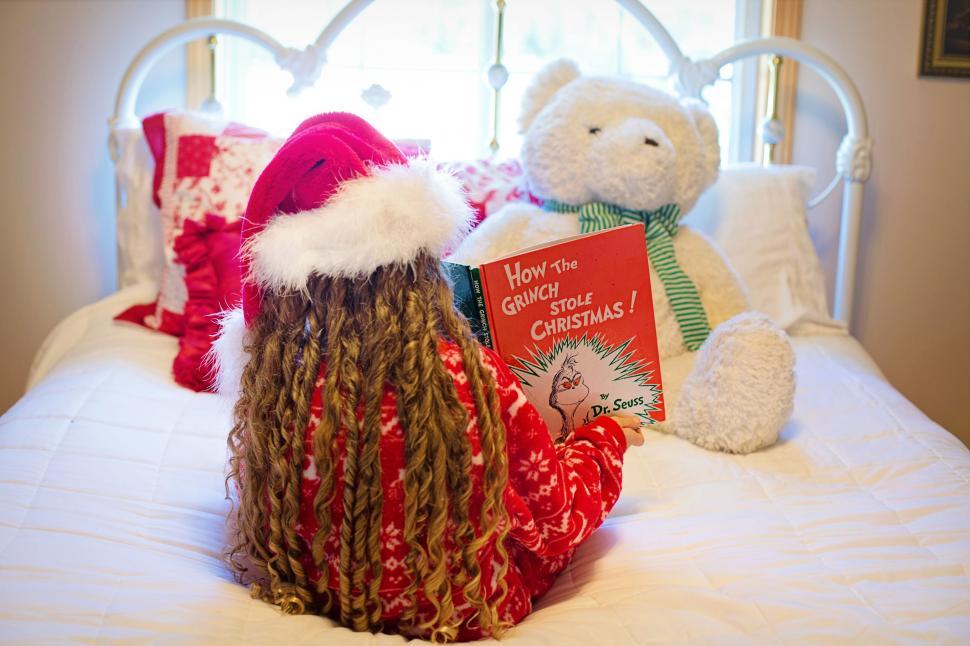 Free Image of Back View Of Little Girl in Santa Hat on Bed 