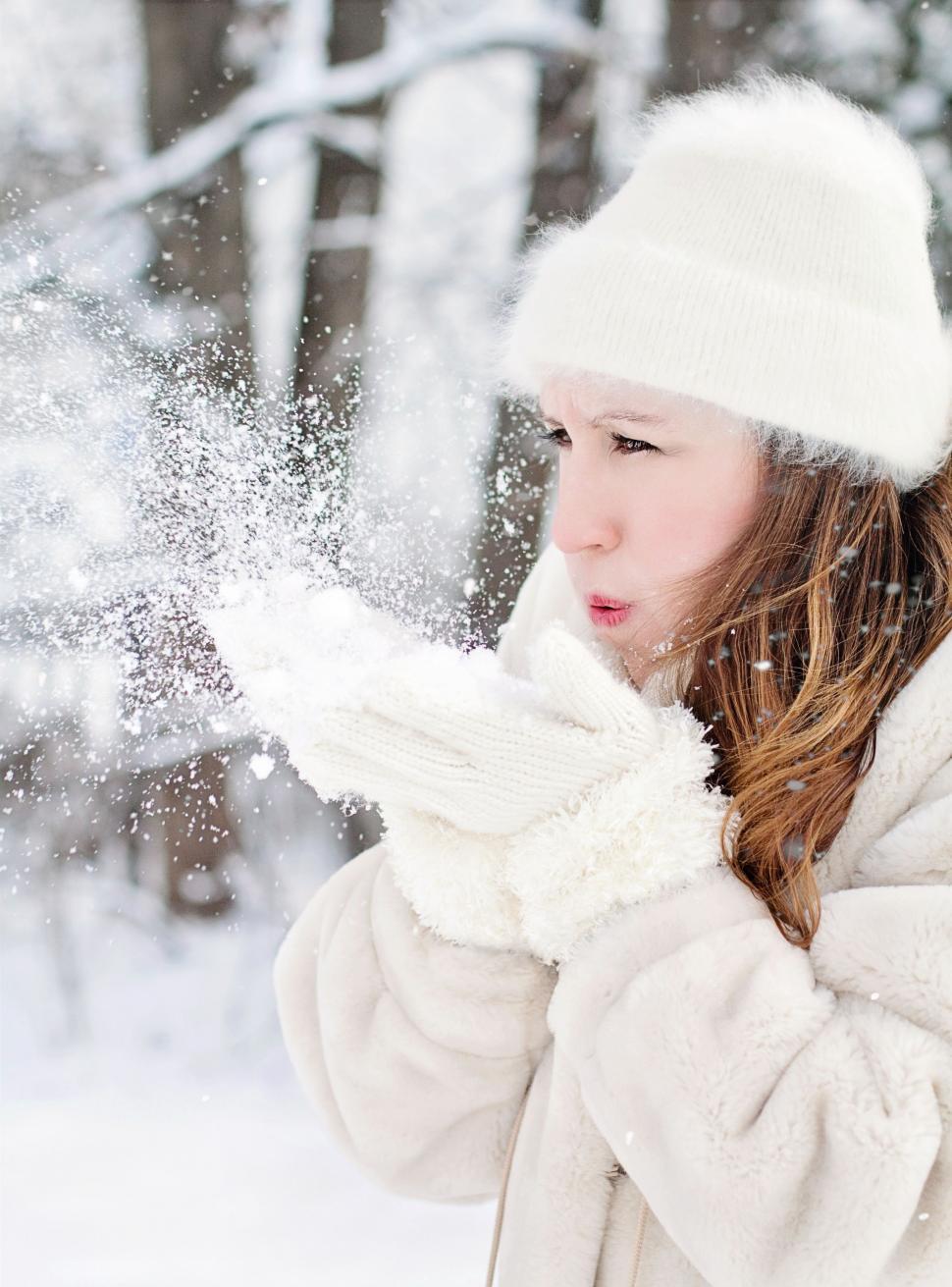 Free Image of Woman in White hat blowing snow 