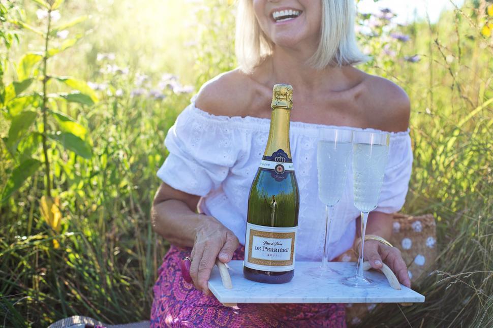 Free Image of Blonde Woman and champagne bottle in the meadow 